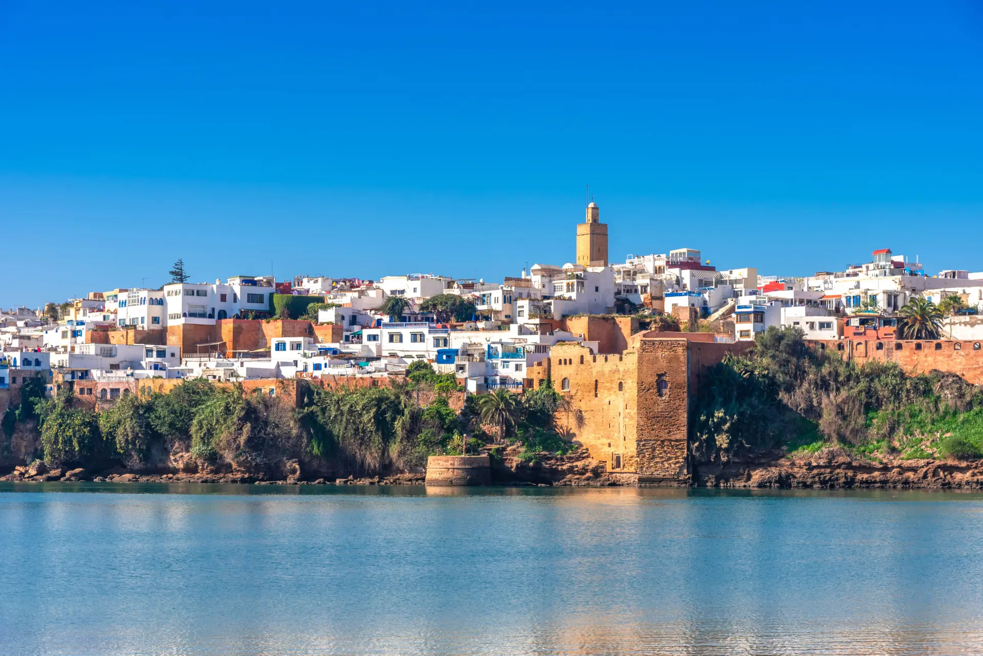 Alt Text: Scenic view of the coastal Kasbah of the Udayas in Rabat surrounded by water.